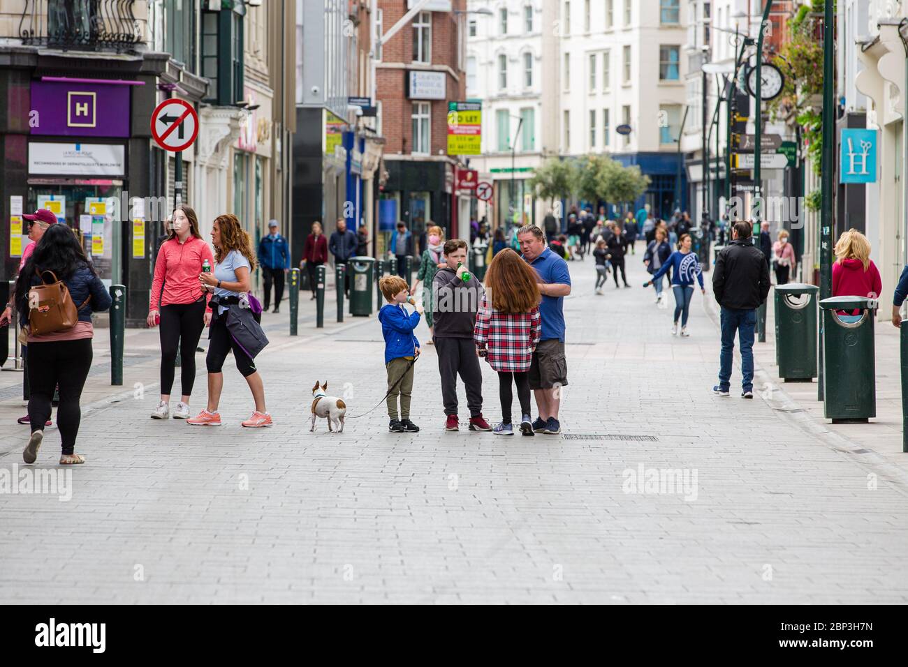 I pedoni camminano attraverso la tranquilla Grafton Street nel centro di Dublino mentre le aziende rimangono chiuse e i piumoni delle cadute a causa della pandemia del coronavirus. Foto Stock