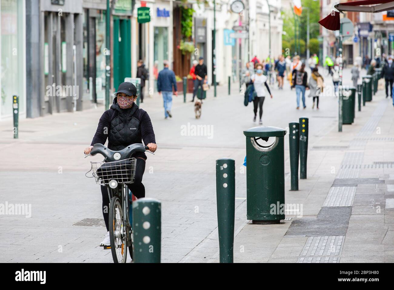 I pedoni camminano attraverso la tranquilla Grafton Street nel centro di Dublino mentre le aziende rimangono chiuse e i piumoni delle cadute a causa della pandemia del coronavirus. Foto Stock