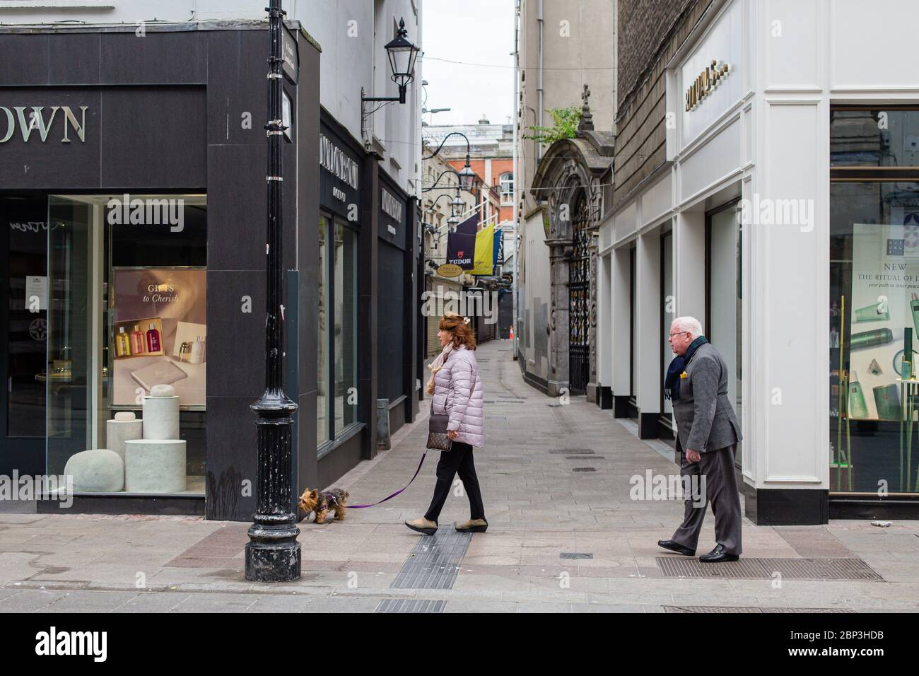 Coppia senior che cammina attraverso una tranquilla Grafton Street nel centro di Dublino, mentre la caduta dei piedi precipita a causa della pandemia del coronavirus. Civid-19 in Irlanda. Foto Stock