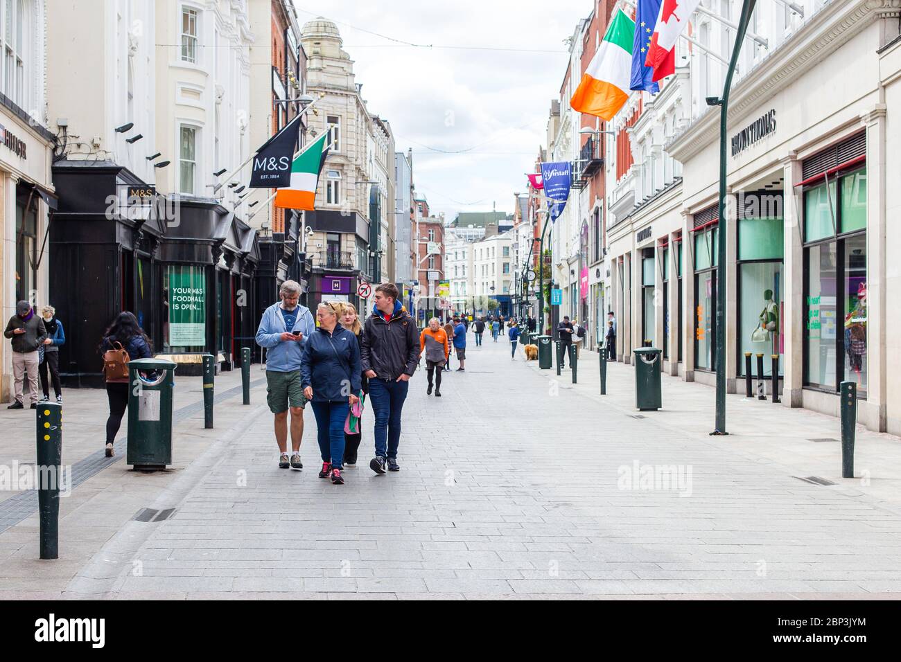 La famiglia in una passeggiata di domenica attraverso una tranquilla Grafton Street nel centro di Dublino, mentre la caduta dei piedi precipita a causa della pandemia di coronavirus. Civid-19 in Irlanda Foto Stock