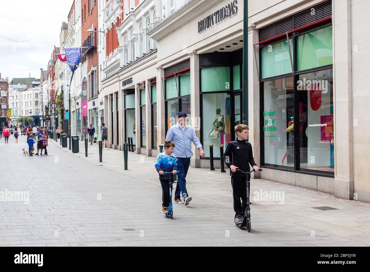 La famiglia in una passeggiata di domenica attraverso una tranquilla Grafton Street nel centro di Dublino, mentre la caduta dei piedi precipita a causa della pandemia di coronavirus. Civid-19 in Irlanda Foto Stock