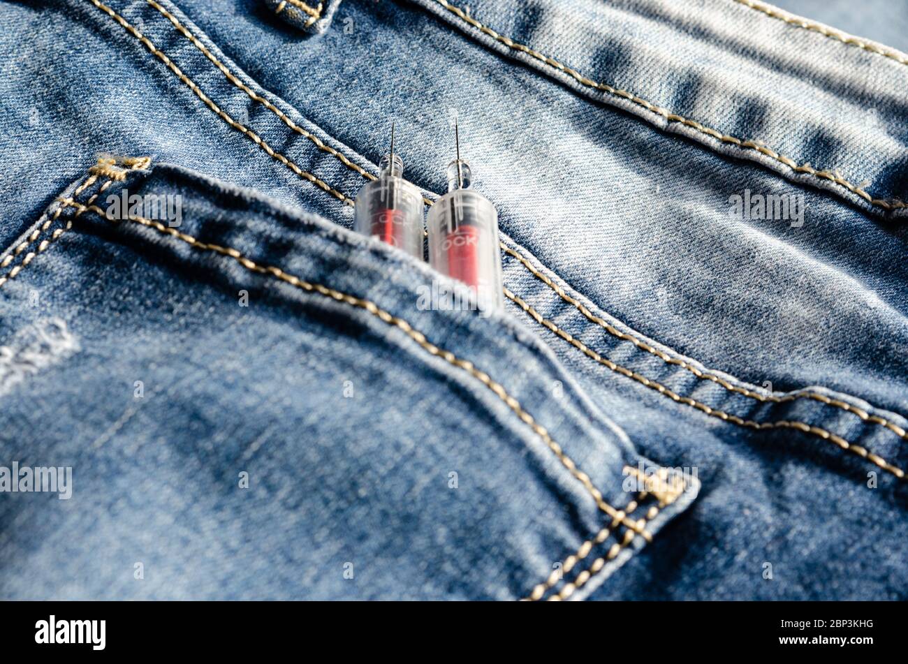 Due siringhe nella tasca posteriore dei pantaloni . Concetto di dipendenza per l'iniezione di droghe . Prevenire e combattere la droga tra i giovani Foto Stock