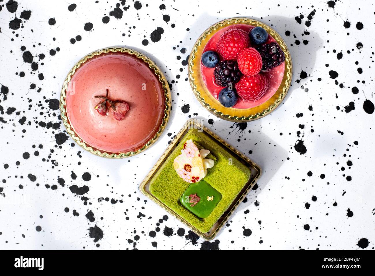 Torte colorate, mousse, torta al gusto di matcha, guarnite con frutti di bosco Foto Stock