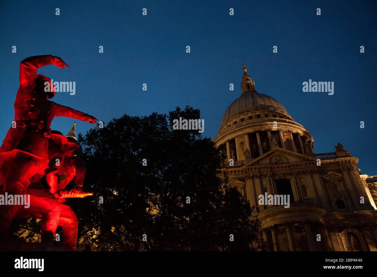 Il monumento ai vigili del fuoco, sul lato sud della cateterdrale di San Paolo, è illuminato da luci rosse tremolanti al crepuscolo. Foto Stock