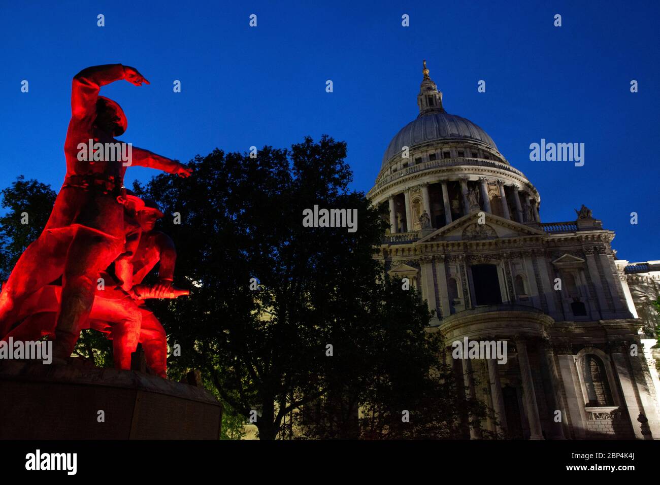 Il monumento ai vigili del fuoco, sul lato sud della cateterdrale di San Paolo, è illuminato da luci rosse tremolanti al crepuscolo. Foto Stock
