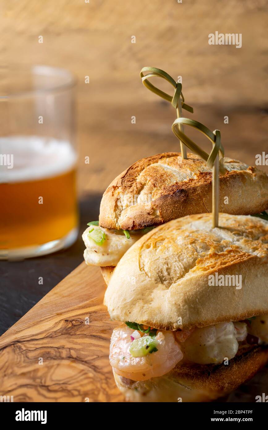 Insalata di gamberi su involtino di hoagie con rucola e patate fritte in forno in casa. Foto Stock