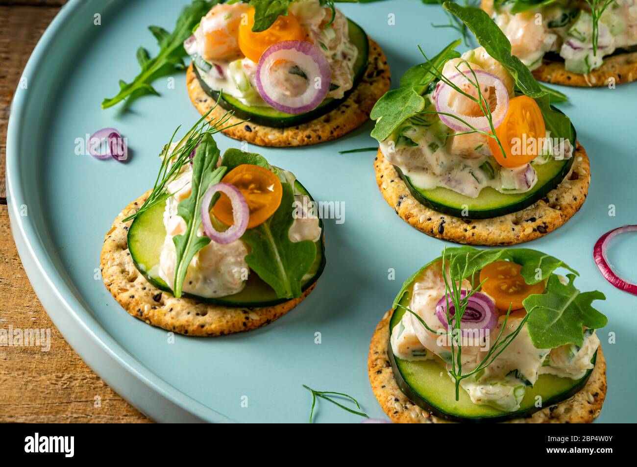 Insalata di gamberi su cracker interi di grano sul piatto di servizio della festa. Foto Stock