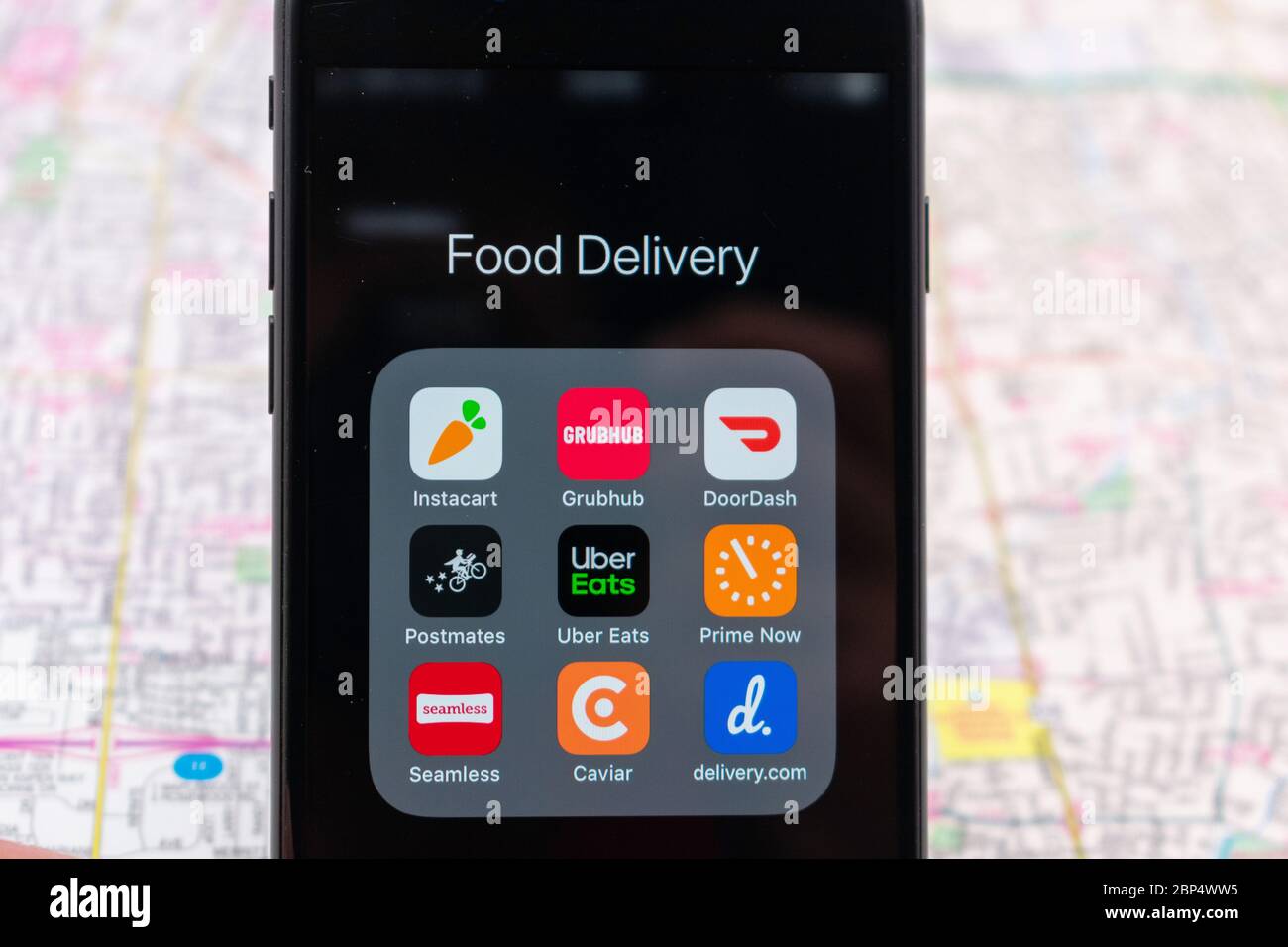 Applicazioni per la consegna di alimenti su smartphone: Instacart, DoorDash, Grubbuhub, Uber Eats, prime Now, Delivery.com, Seamless, Postmates, Caviar. Mappa sfocata b Foto Stock