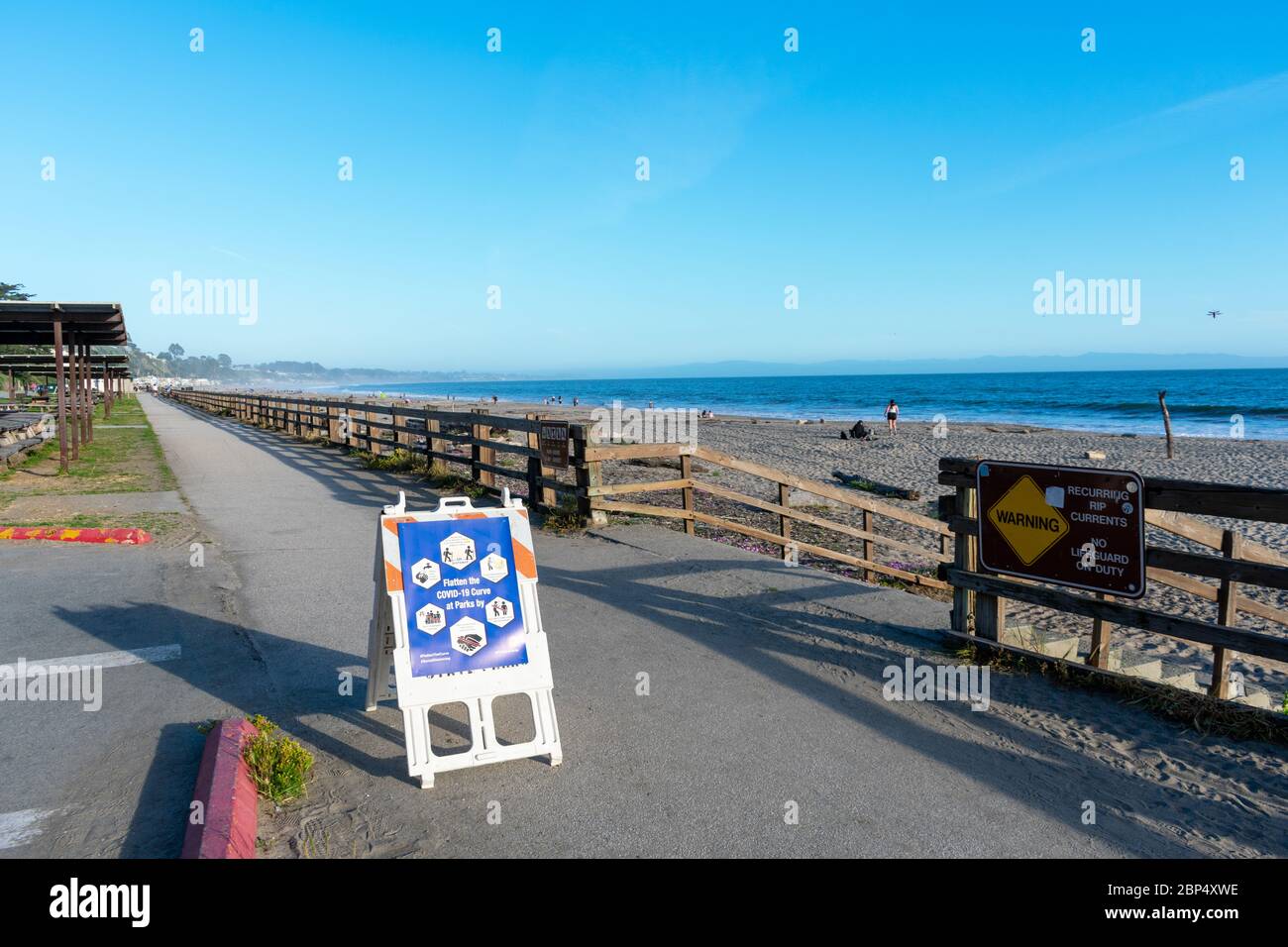 Cartello su sentiero per i visitatori della spiaggia del parco statale per praticare la distanza sociale e appiattire la curva per prevenire la diffusione COVID-19 - Santa Cruz, California, U. Foto Stock