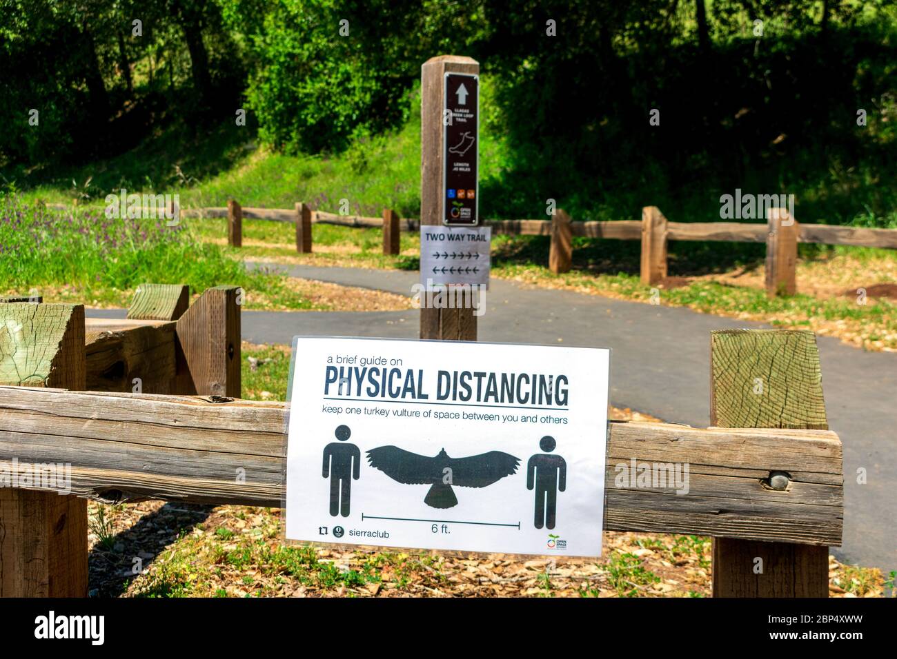 Segno di distanza fisica con avvoltoio tacchino come riferimento pubblicato all'inizio del sentiero escursionistico nel parco - San Jose, California, USA - Aprile, 2020 Foto Stock