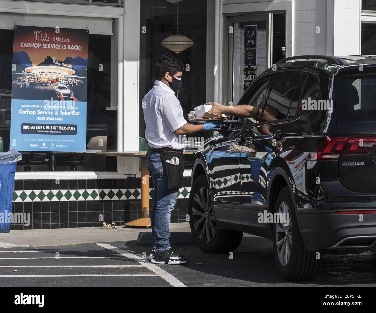 San Francisco, Stati Uniti. 18 maggio 2020. Un'auto hop porta un ordine a un cliente a Mel's Drive in San Francisco domenica 17 maggio 2020. La catena, presente nel film "American Graffiti" è tornata a prendere ordini e consegnare il cibo da portare fuori alle auto in attesa. Photo by Terry Schmitt/UPI Credit: UPI/Alamy Live News Foto Stock