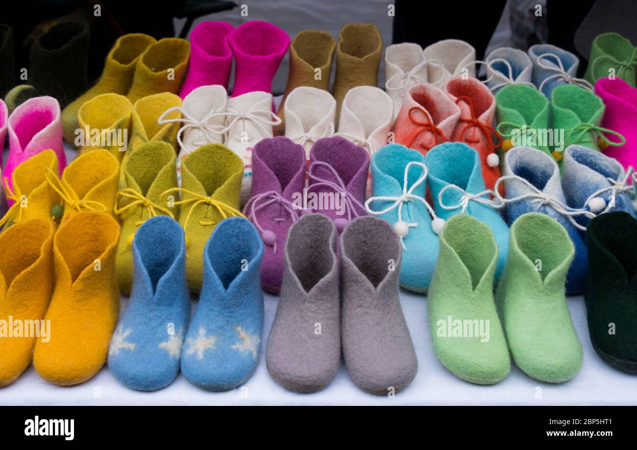 Una stalla vende scarpe, stivaletti, pantofole, scarpe per bambini, tessuti, tessuti colorati, fatti a mano, in tutti i tipi di colori brillanti. Alla fiera di San Casimiro a Vilnius, Foto Stock