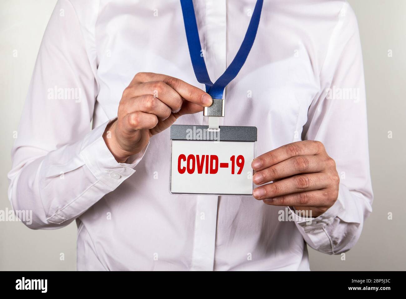 COVID-19. Coronovirus - focolaio di disagio che è stato segnalato per la prima volta da Wuhan, Cina. Identità del personale con cordino blu Foto Stock