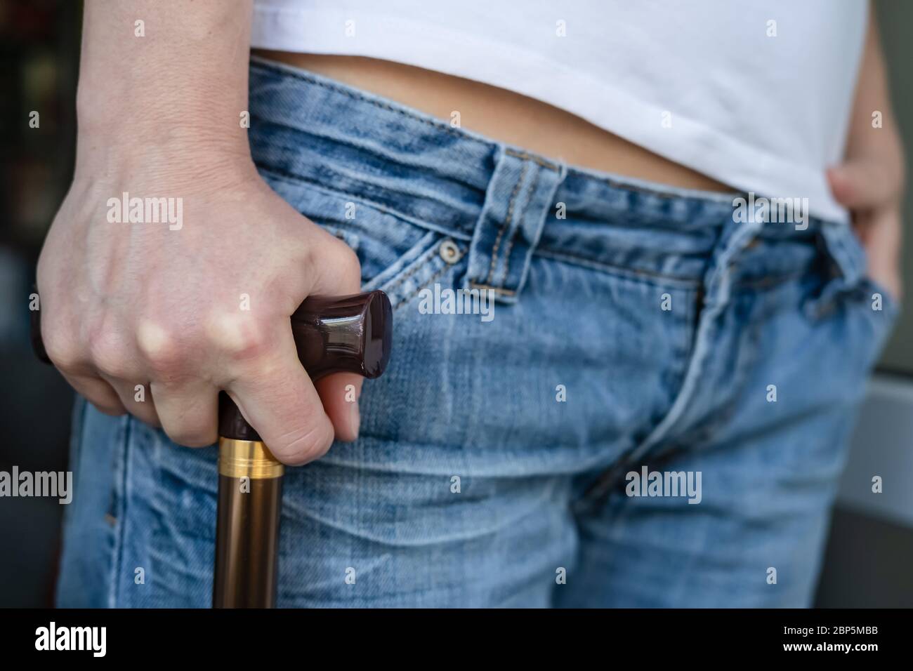Mano di una giovane donna con un cane che è temporaneamente costretto a camminare e appoggiarsi su di esso dopo una ferita sportiva. Foto Stock