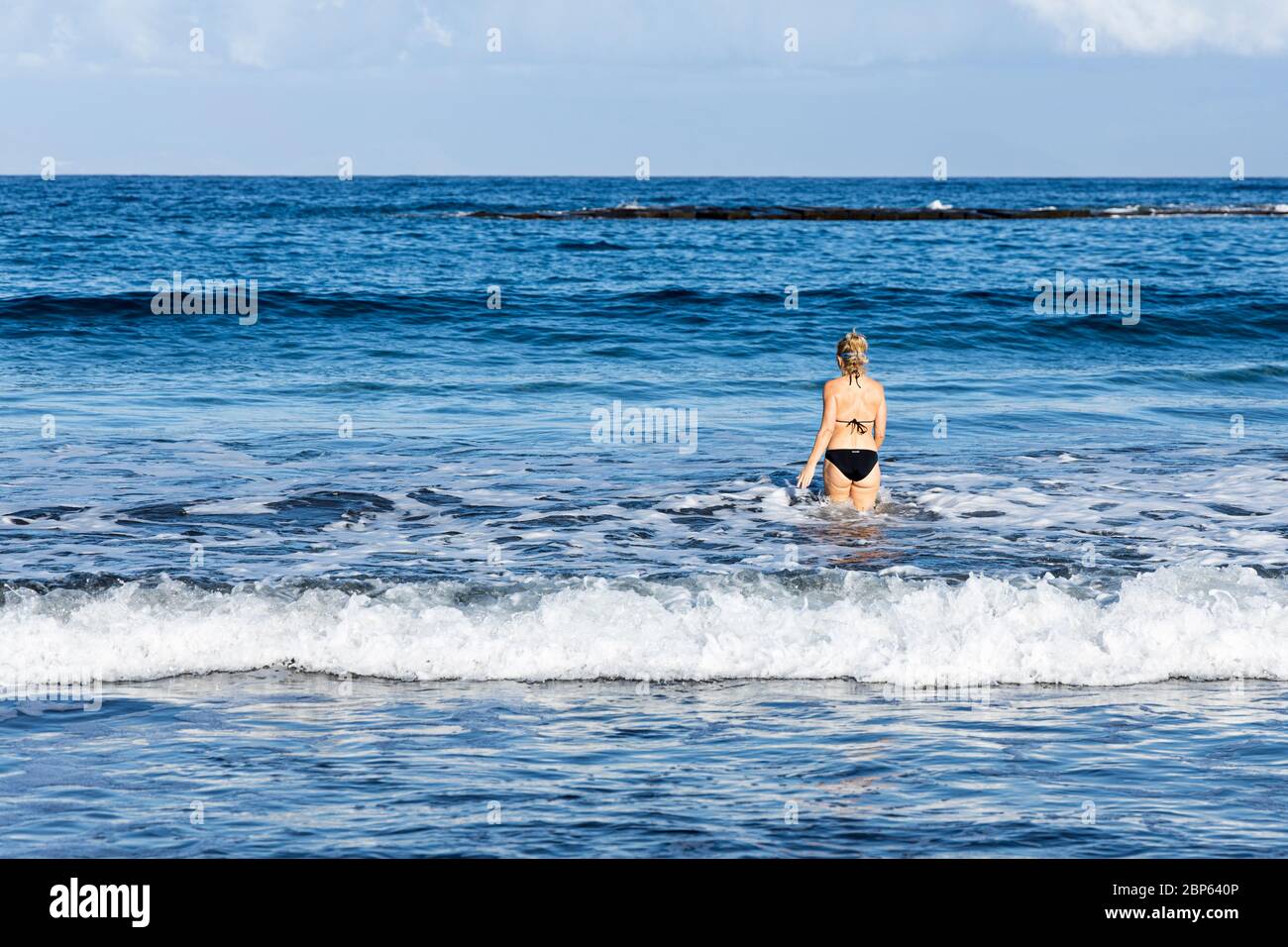 Donna entra in mare per una nuotata illecita durante la prima fase di de-escalation del Covid 19, coronavirus, stato di emergenza, Fanabe, Costa Adeje, Foto Stock
