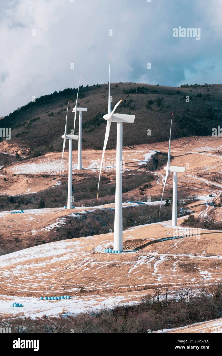Mulino a turbina elettrica su un terreno agricolo innevato. Vista panoramica invernale dalla cima. Foto Stock