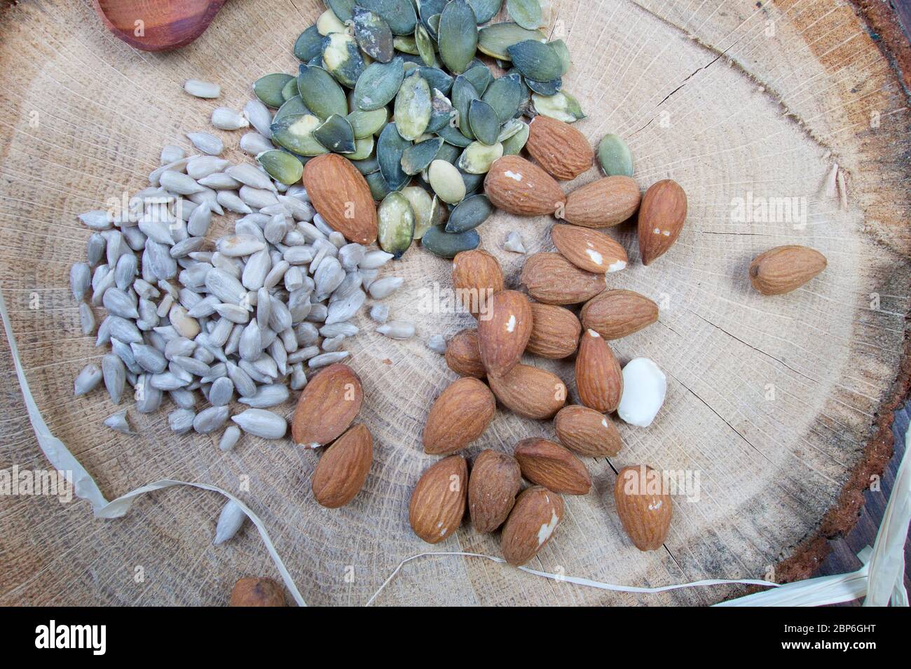 Mandorla, girasole e zucca semi sani su tavola di legno con motivo Foto Stock