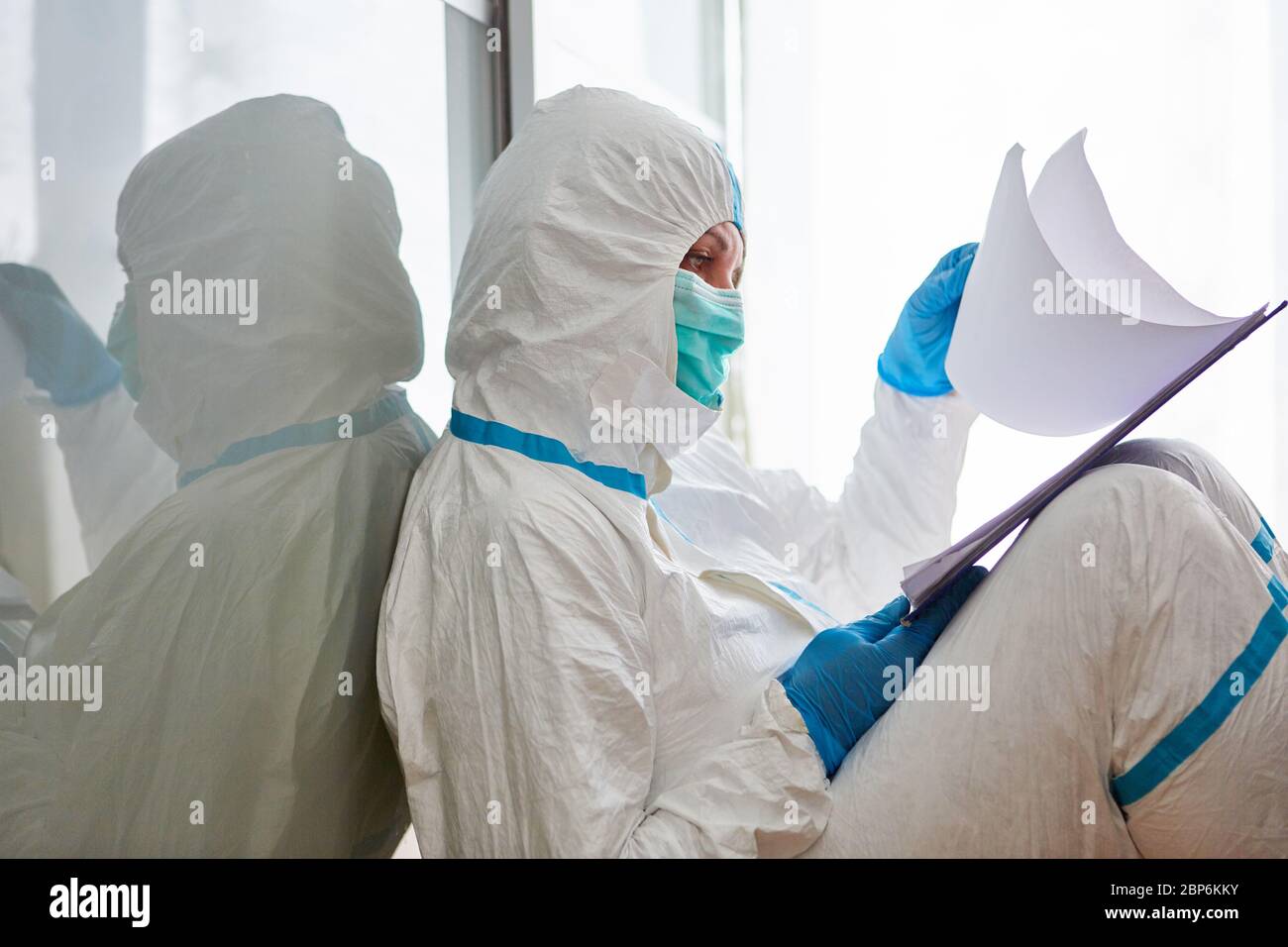 Scout di contenimento o personale infermieristico in studi di abbigliamento protettivo elenco visitatori o monitoraggio dei contatti a causa di pandemia di coronavirus Foto Stock