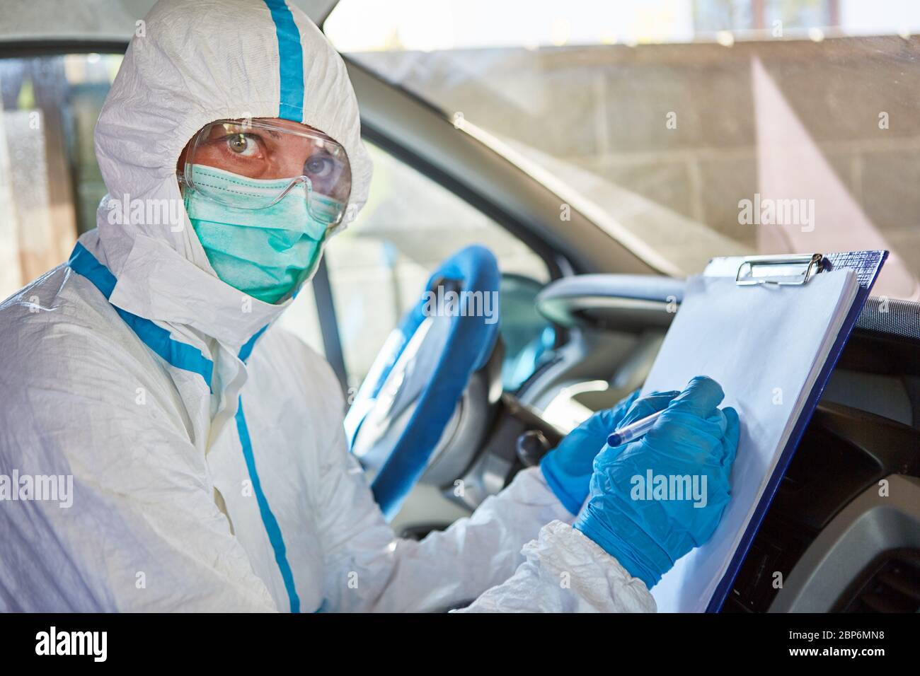 Paramedico come scout di contenimento con lista per il monitoraggio dei contatti in ambulanza nel caso di una pandemia di coronavirus Foto Stock