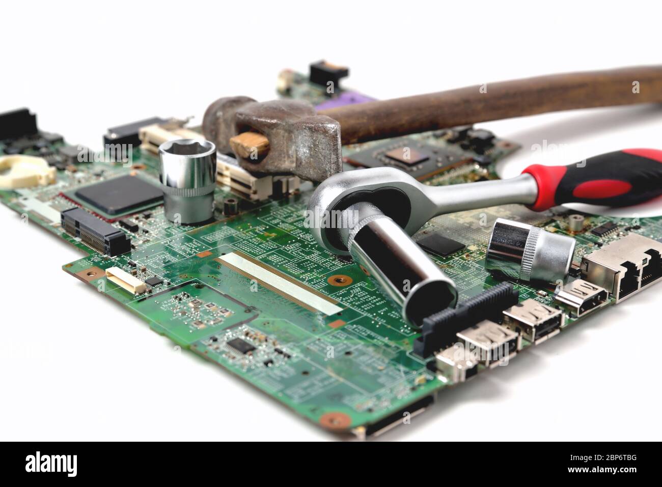 Vecchio martello e una chiave su un vecchio microcircuito per un computer su sfondo bianco, primo piano Foto Stock