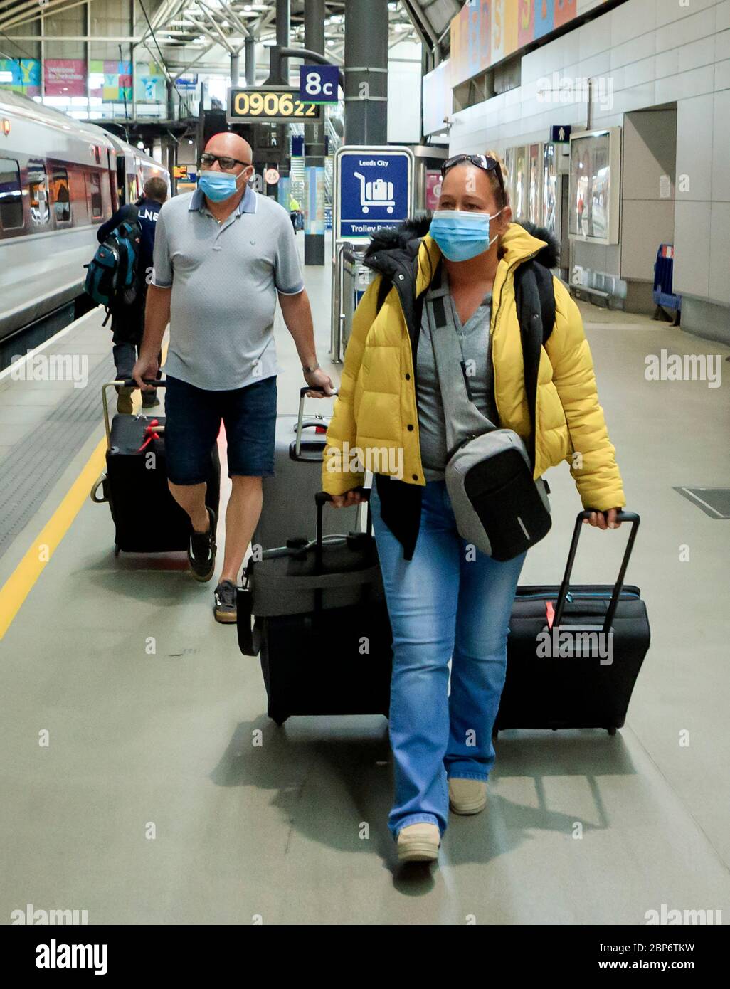 La gente indossa maschere alla stazione di Leeds, poiché i servizi ferroviari aumentano come parte dell'allentamento delle restrizioni di blocco del coronavirus. Foto Stock