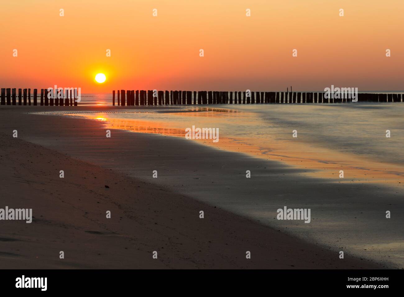 Tramonto estivo con acqua frangente al Mare del Nord e marea crescente Foto Stock