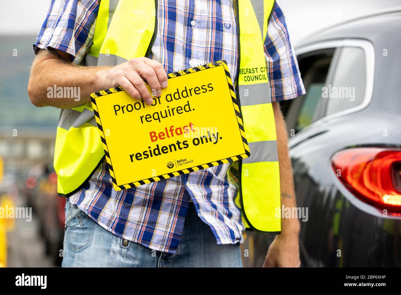 Un membro del personale del Blackstaff Way Recycling Center, nella zona ovest di Belfast, mostra un cartello il pubblico deve fornire la prova dell'indirizzo per utilizzare la struttura che ha aperto lunedì dopo un periodo di chiusura. Foto Stock