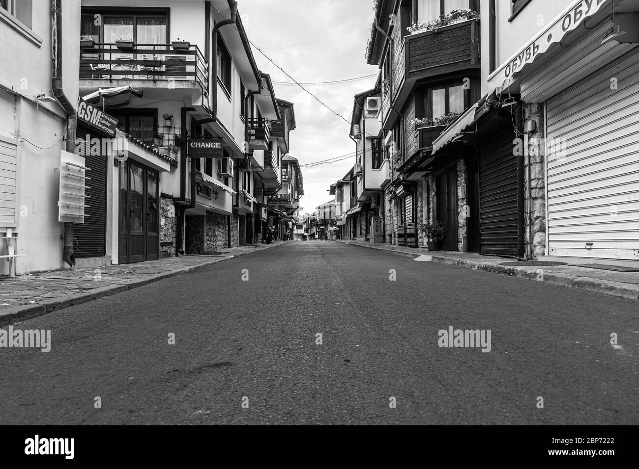 NESSEBAR, BULGARIA - 22 GIUGNO 2019: Bella e stretta strada con ristoranti, caffè e negozi dell'antica città di mare. Strade deserte al mattino presto. Bianco e nero. Foto Stock