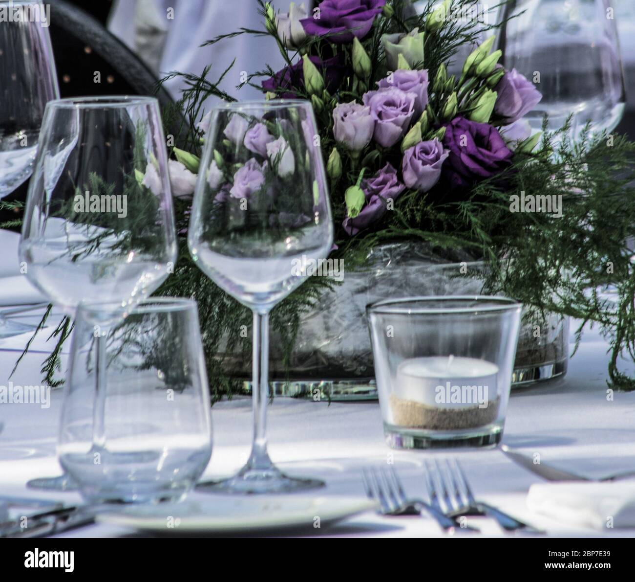 tavolo per cena a lume di candela con fiori al centro Foto Stock