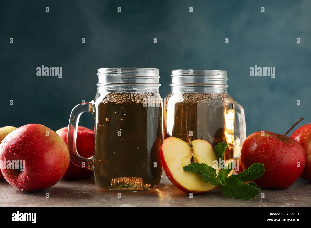 Composizione con sidro e mele su tavola grigia Foto Stock