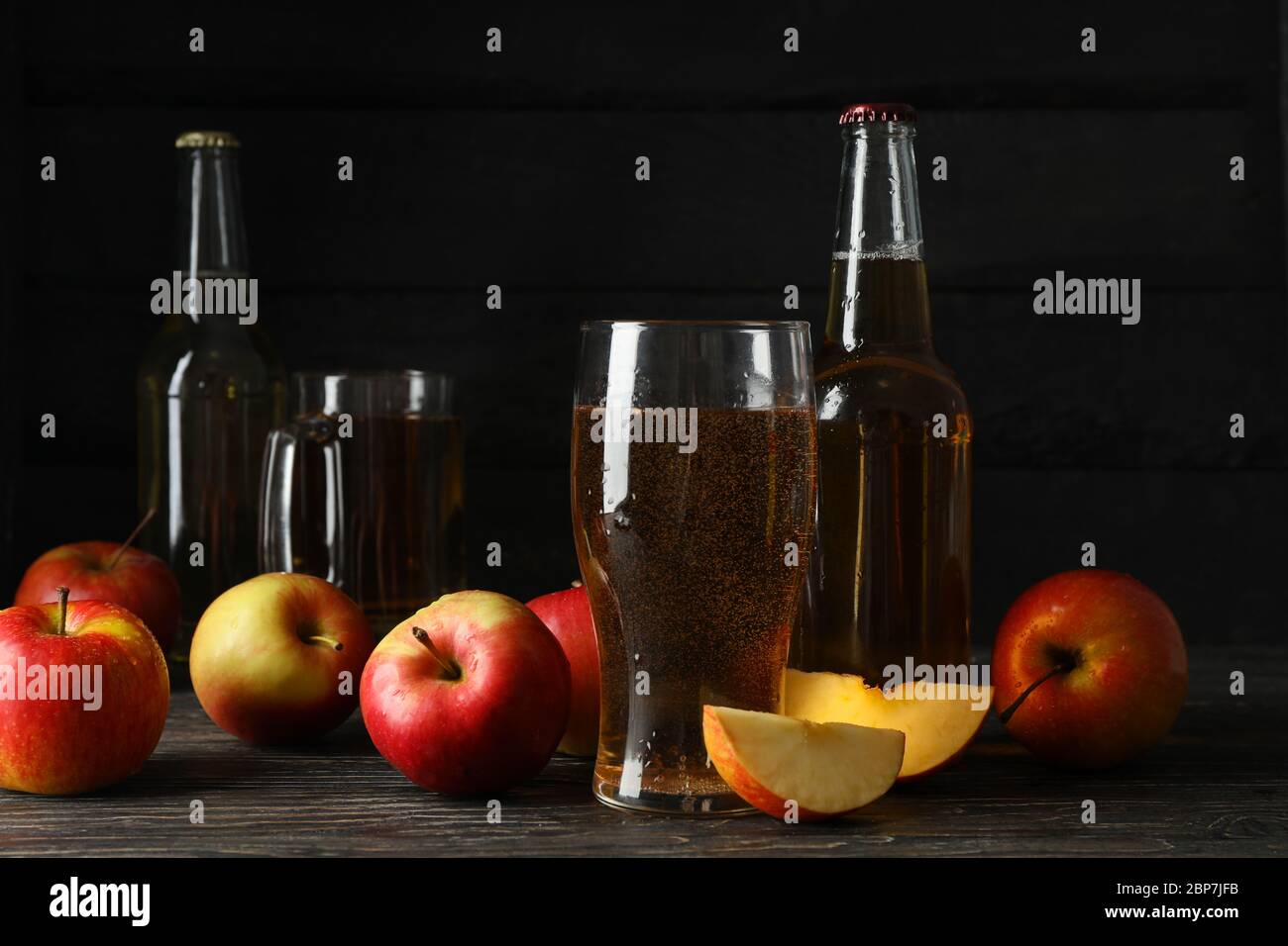 Composizione con sidro e mele su fondo ligneo Foto Stock