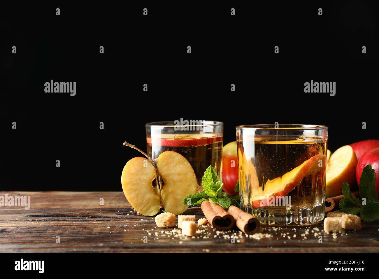 Composizione con sidro, zucchero, cannella e mele su tavola di legno Foto Stock