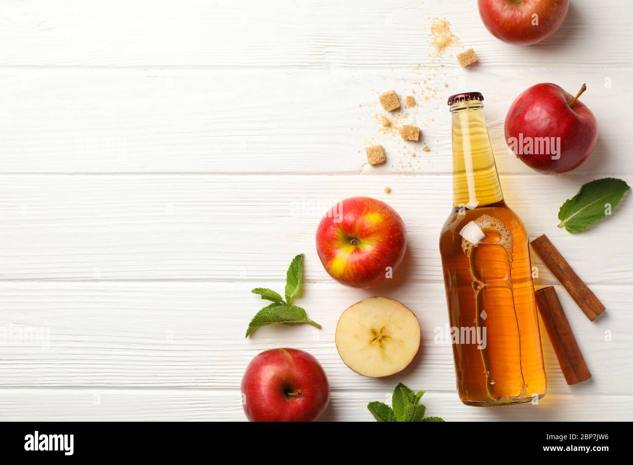 Composizione con sidro, cannella e mele su fondo di legno bianco Foto Stock