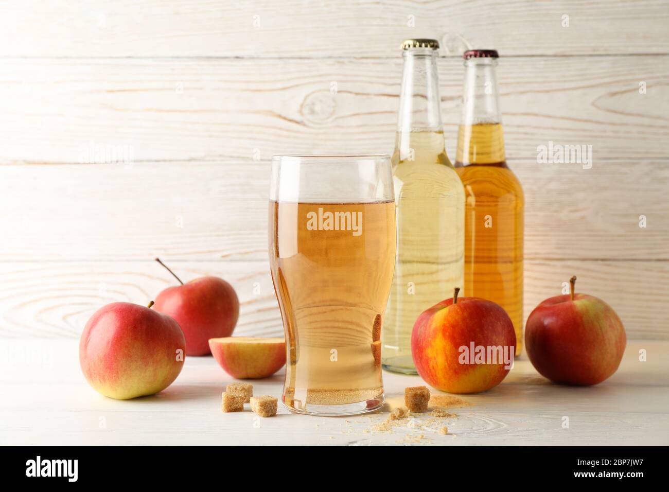 Composizione con sidro, zucchero e mele su fondo di legno bianco Foto Stock