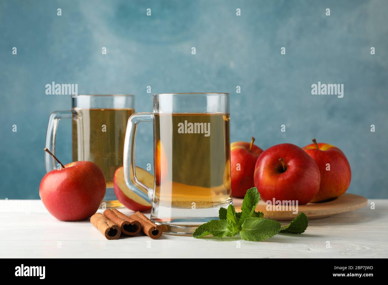 Composizione con sidro, cannella e mele su fondo di legno bianco Foto Stock