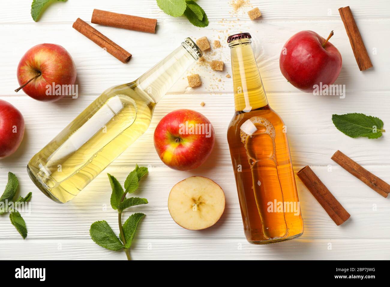 Composizione con sidro, cannella e mele su fondo di legno bianco Foto Stock