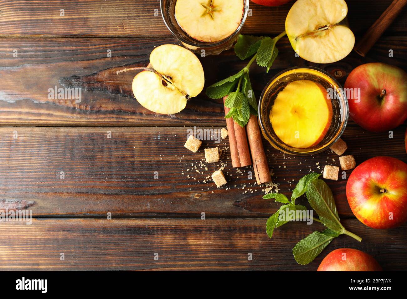 Composizione con sidro, zucchero, cannella e mele su tavola di legno Foto Stock