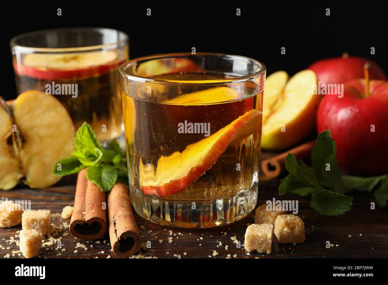 Composizione con sidro, zucchero, cannella e mele su tavola di legno Foto Stock