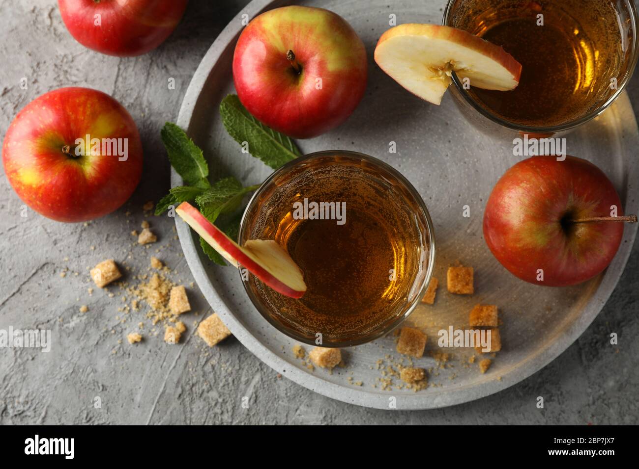 Composizione con sidro, zucchero e mele su tavola grigia Foto Stock