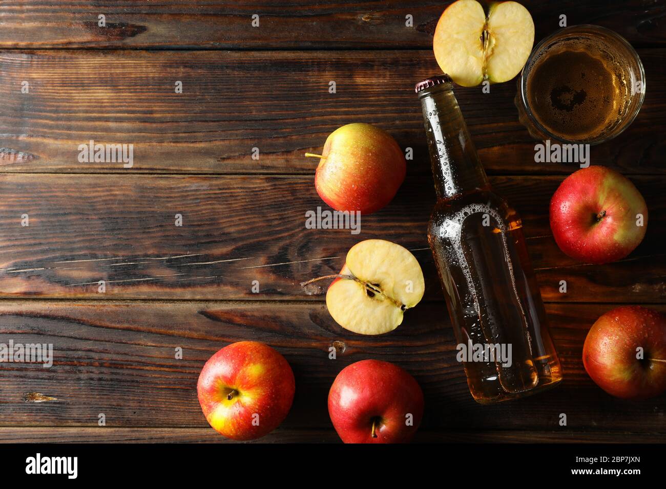 Composizione con sidro e mele su fondo ligneo Foto Stock