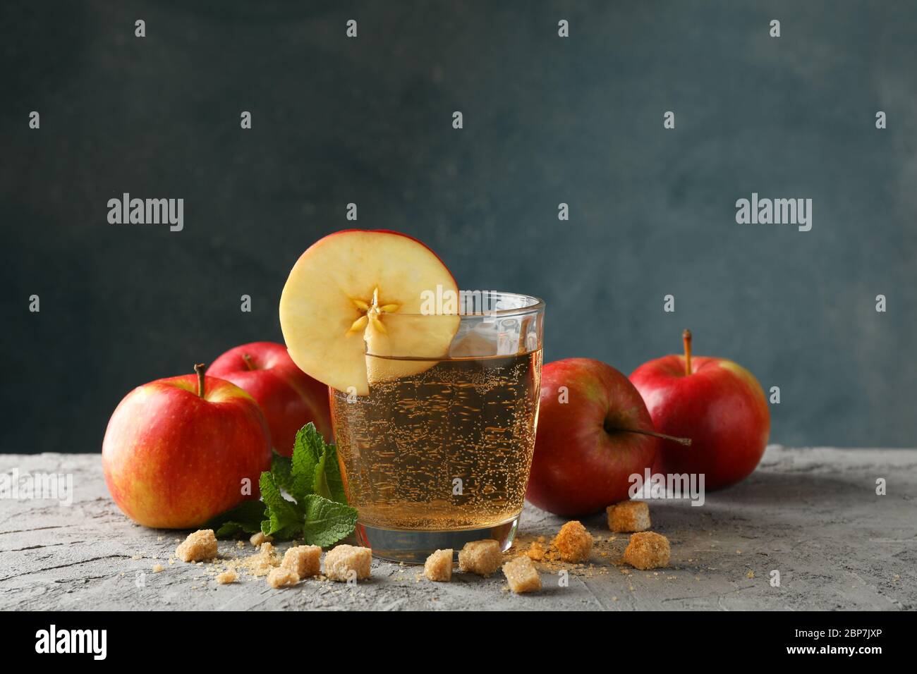 Composizione con sidro, zucchero e mele su tavola grigia Foto Stock