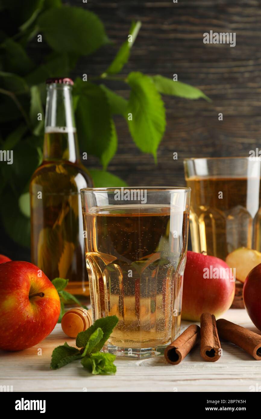 Composizione con sidro, cannella e mele su fondo ligneo Foto Stock