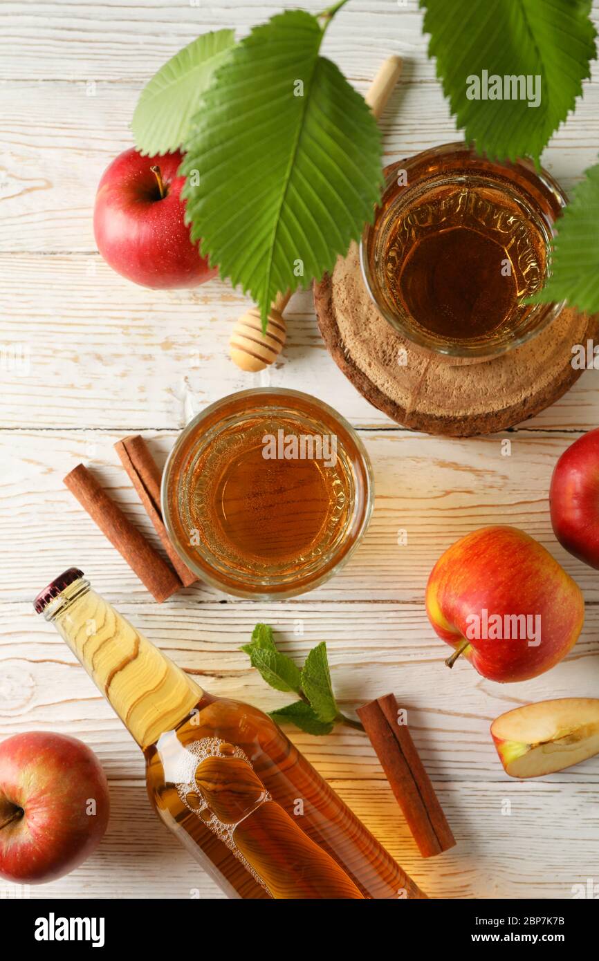 Composizione con sidro, cannella e mele su fondo ligneo Foto Stock