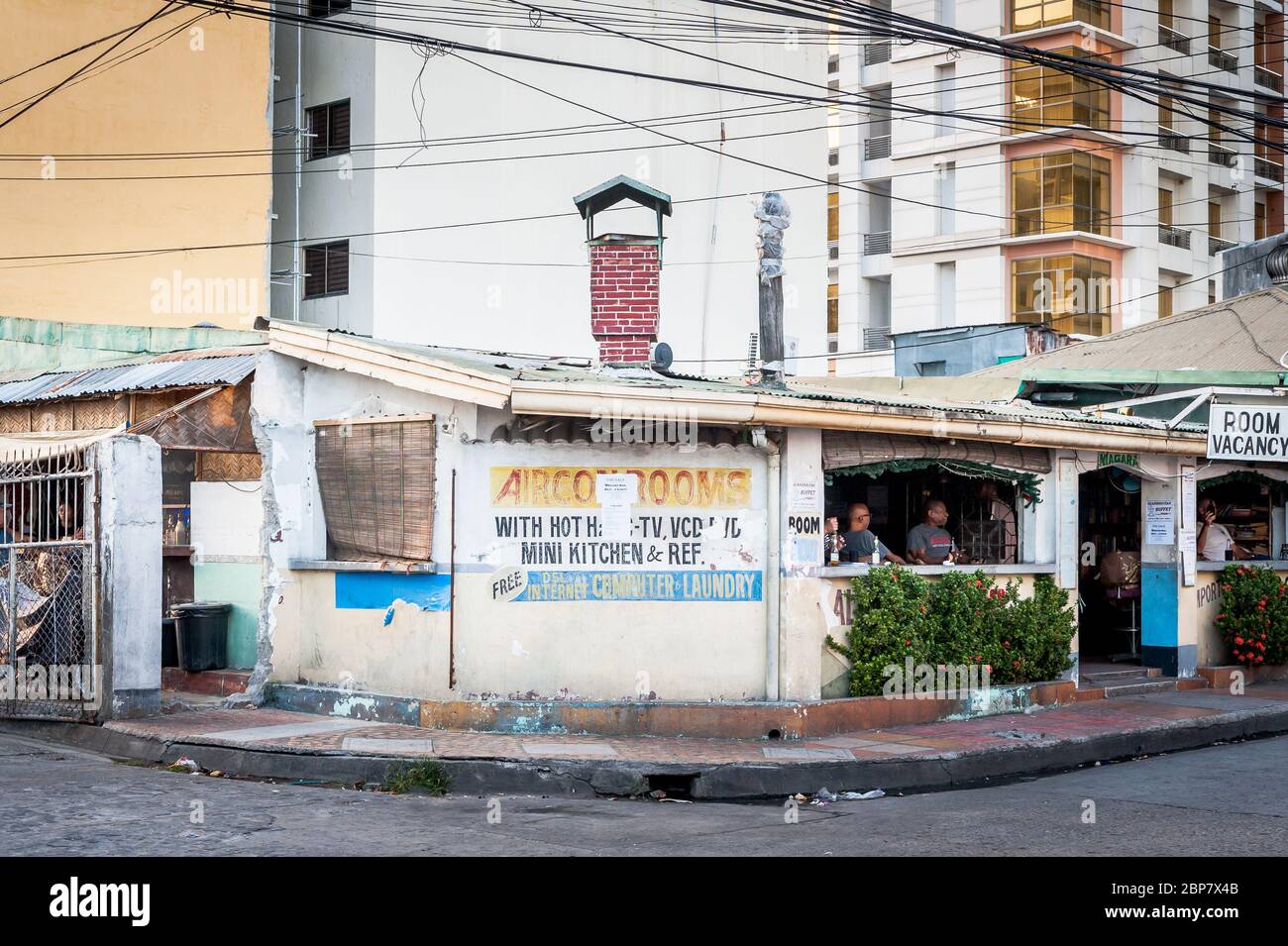 Uno dei più antichi bar e hotel di Angeles City Filippine si trova sotto il moderno sviluppo di appartamenti. Foto Stock
