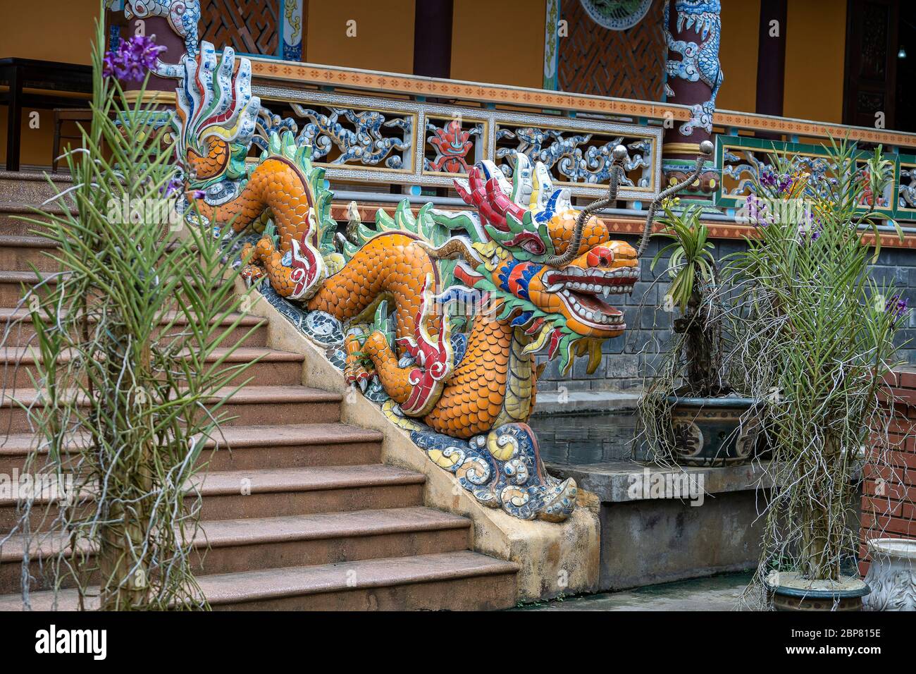 Scultura colorata drago all'ingresso di un tempio buddista sulla scalinata della città di Danang, Vietnam. Primo piano Foto Stock