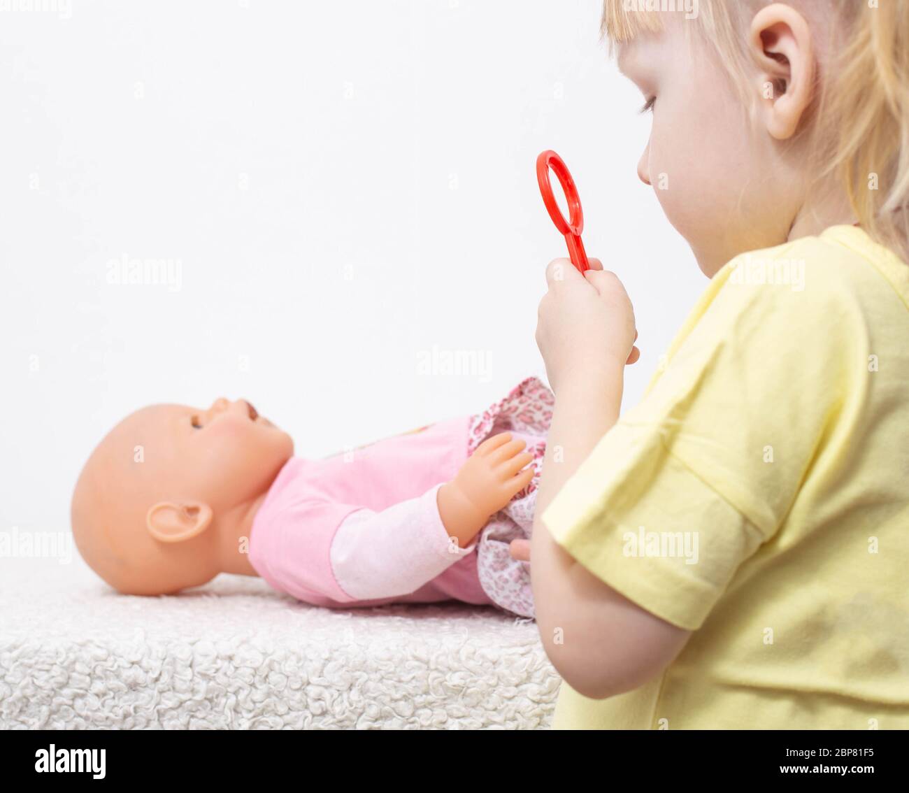 La bambina tratta una bambola il suo giocattolo. Il concetto di oncologia pediatrica e medicina immunologica, chirurgia pediatrica Foto Stock