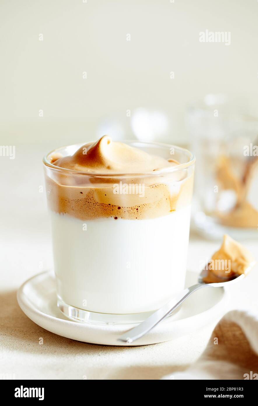 Bevanda coreana alla moda montata con schiuma di caffè istantaneo su sfondo beige primo piano fuoco selettivo Foto Stock