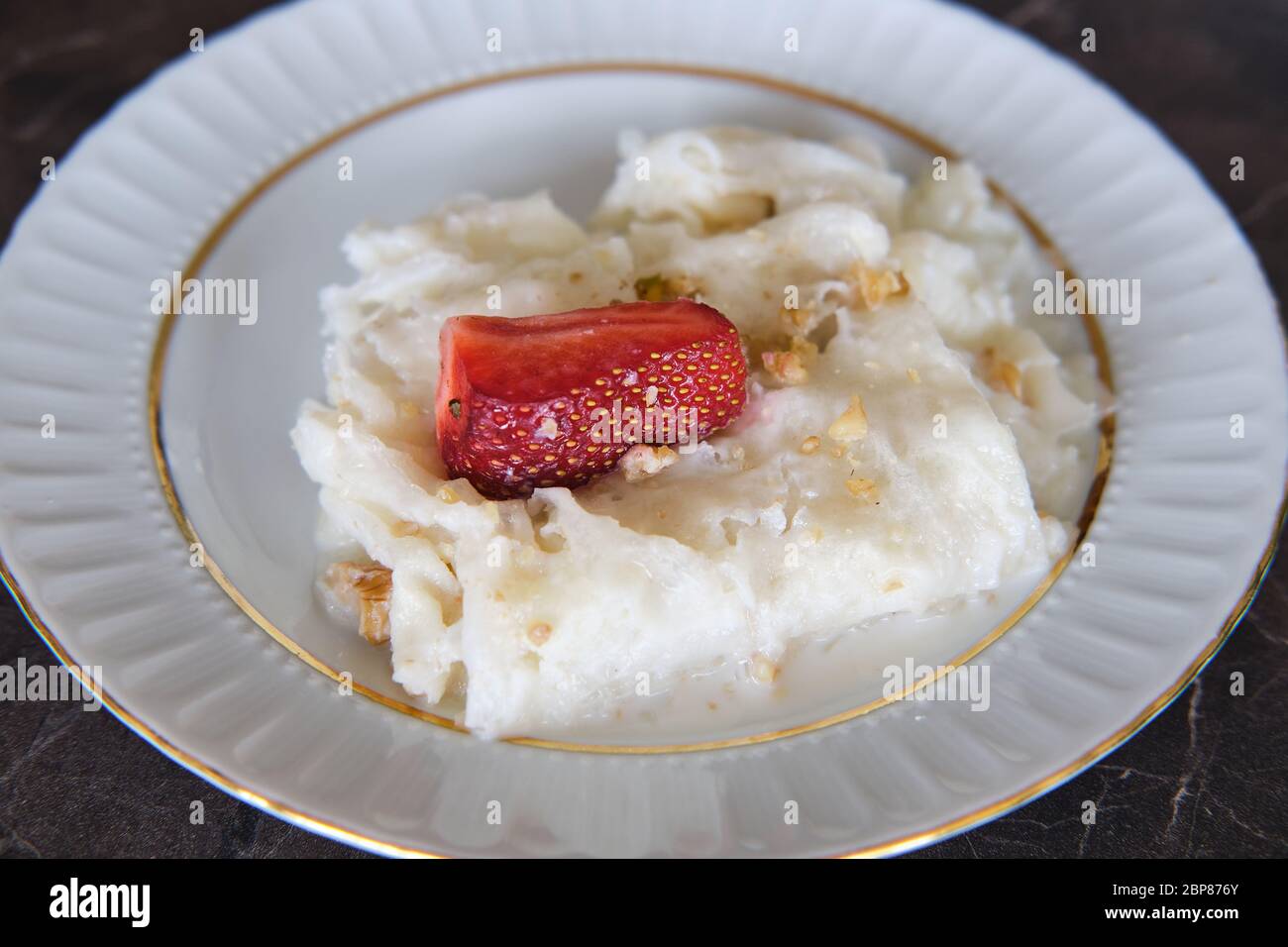 Tradizionale turco Ramadan Dessert Gullac . È fatto con gullac (cialda di riso o fogli di carta di riso), latte, acqua di rosa, noce, vaniglia. Foto Stock