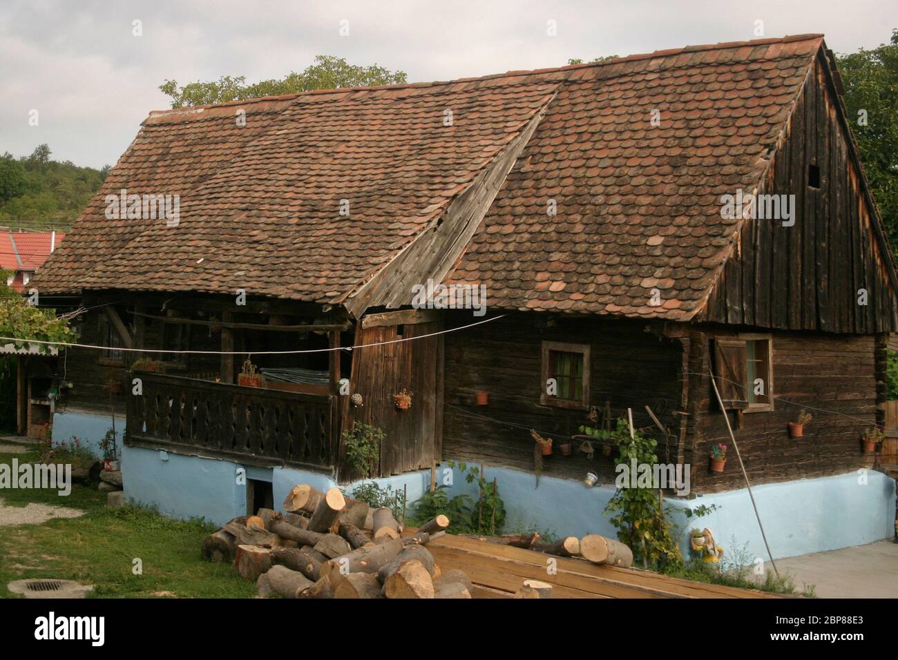 Casa tradizionale in legno con portico e tetto in tegole nella Contea di Sibiu, Transilvania, Romania Foto Stock