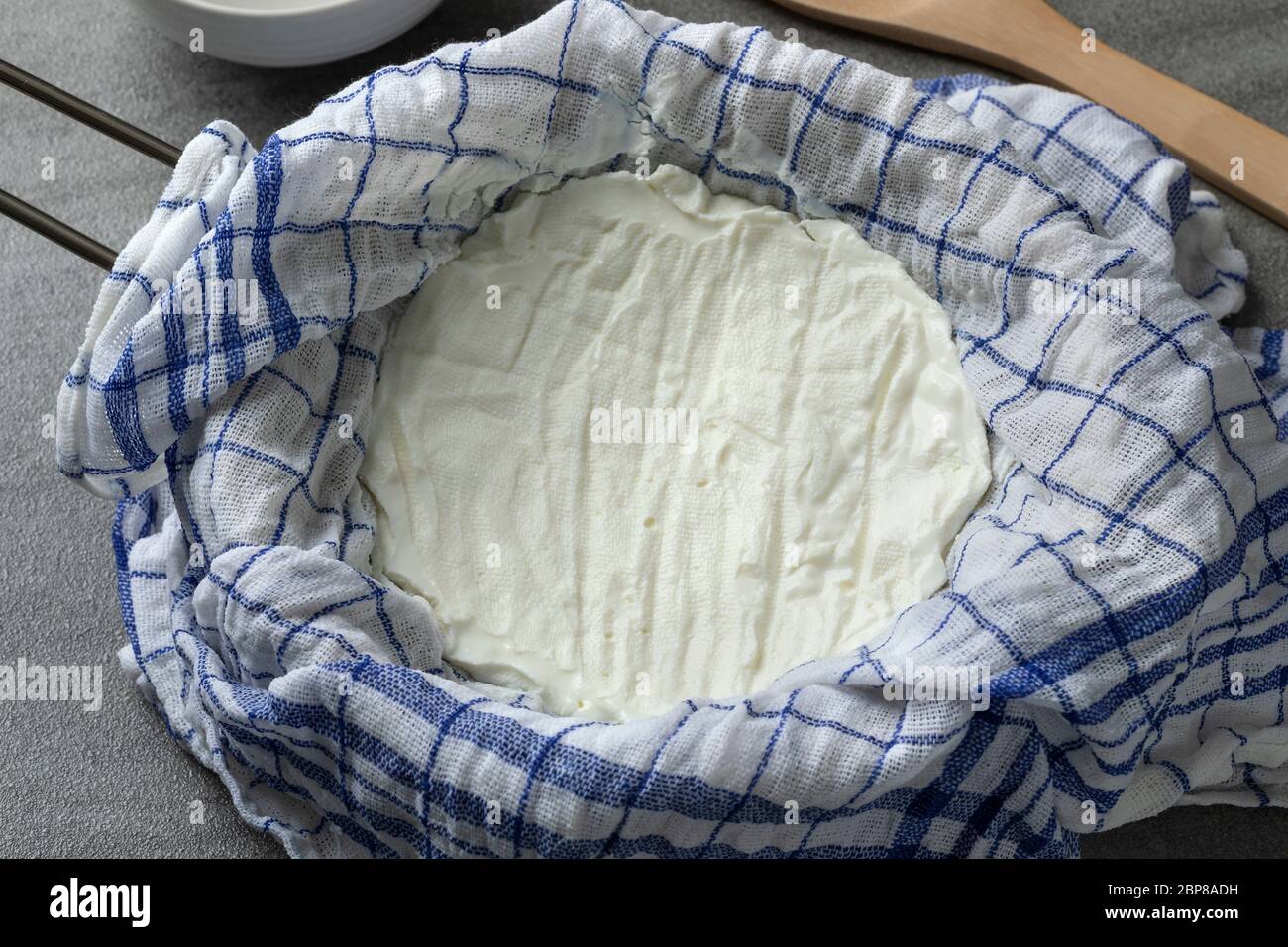 Yogurt fatto in casa teso da vicino in un setaccio Foto Stock